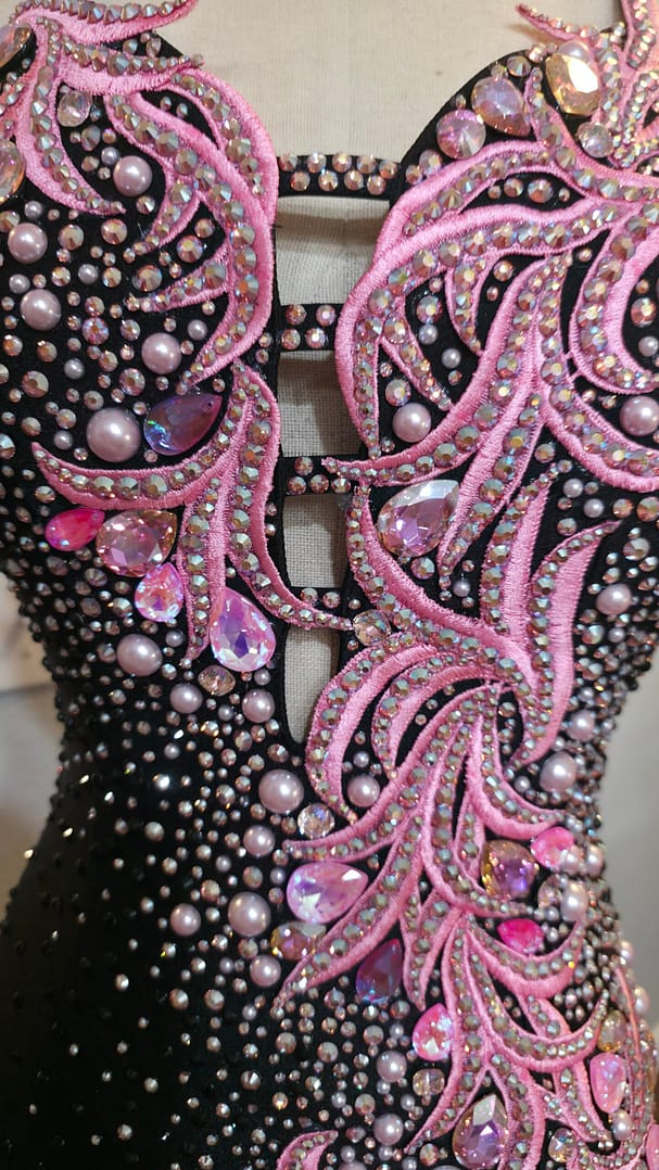 Detailed front view of the Blush Noir dress showcasing pink rhinestone appliqué, pearls, and sparkling crystal embellishments