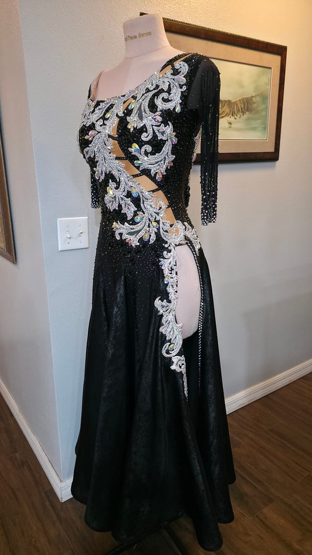 Full front view of the Crystal Nocturne Signature Series black ballroom competition dress with asymmetrical neckline, crystal embellishments, high side slit, and elegant full ballroom skirt.