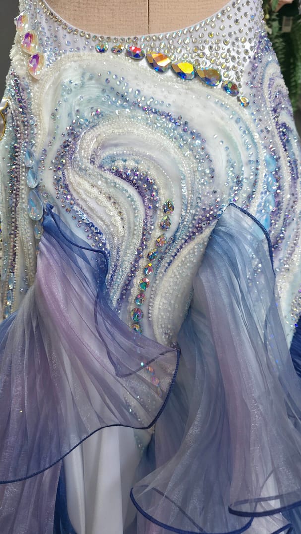 Close-up of the flowing wave-inspired crystal pattern in white, blue, lilac, and silver tones