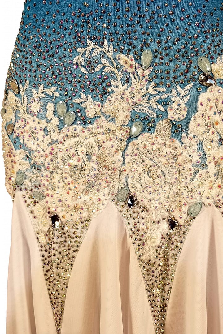 Blue fire ballroom gown — stonework close-up — Macro detail of the waistline where white lace and floral appliqué meets the blue bodice, accented with large, pear-shaped iridescent crystals and small seed beads.