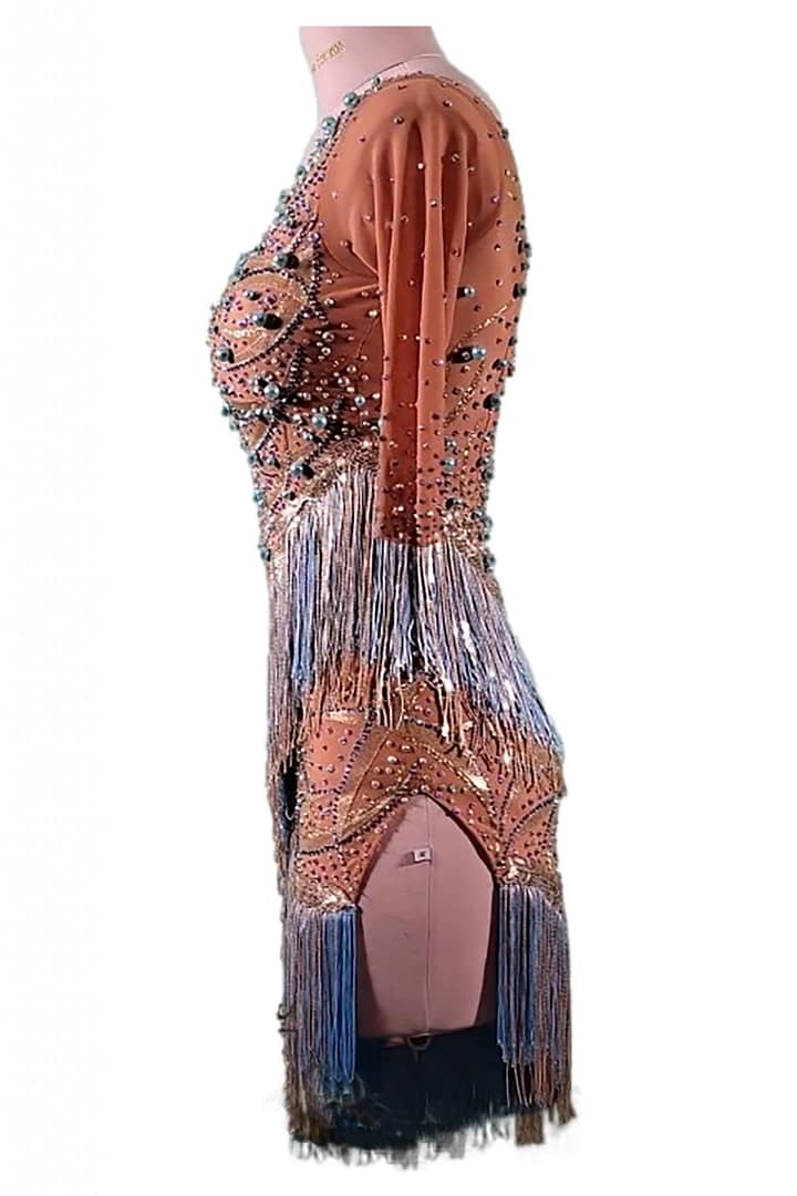 Devi Latin dress - side view - featuring nude mesh base with peach embellishments, crystal detailing, dramatic fringe skirt, and high slit