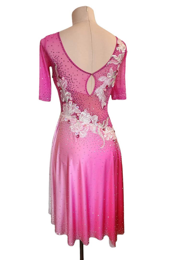 Gia Latin dress — back view — deep V-back with keyhole opening, accented by silver floral appliqué and rhinestone detailing on pink mesh.