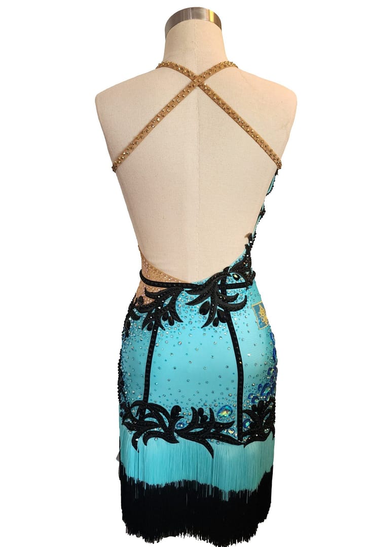 Aqua Noir Latin dress back view open back with gold beaded criss-cross straps and black appliqué design.
