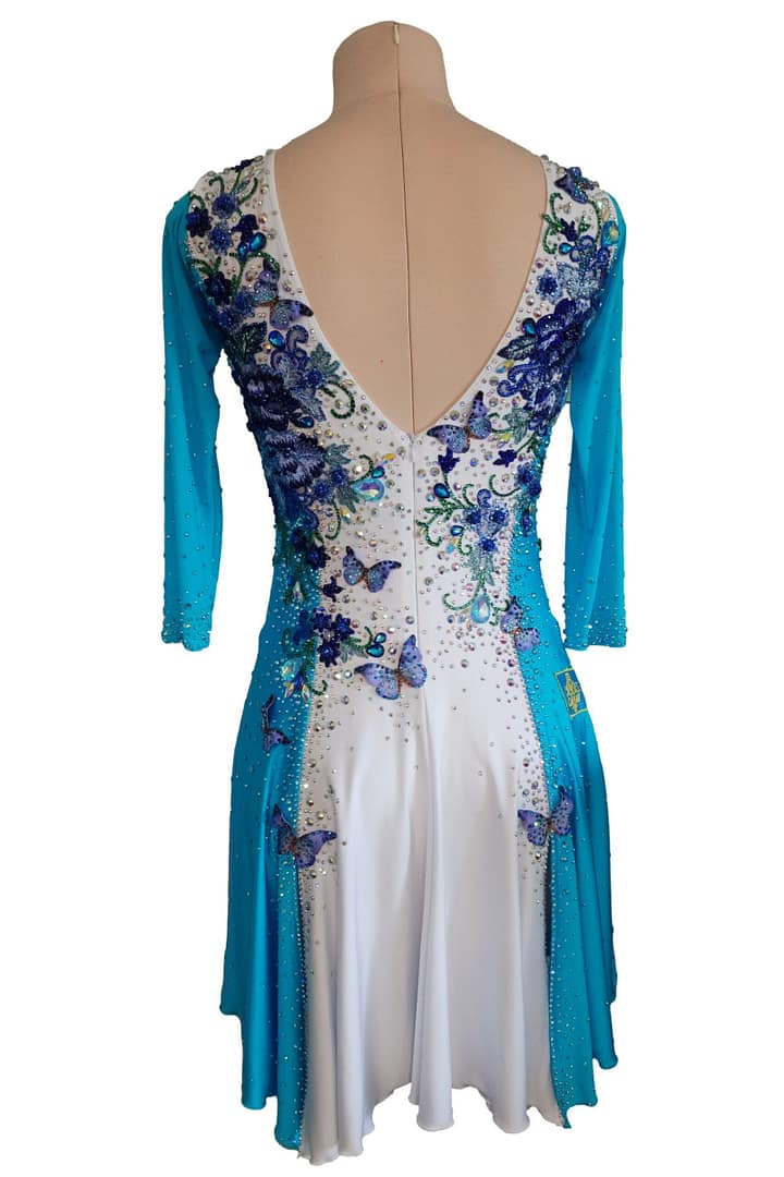 Back view of Azure Grace Latin dress featuring deep V-back neckline with blue floral embroidery and rhinestone accents