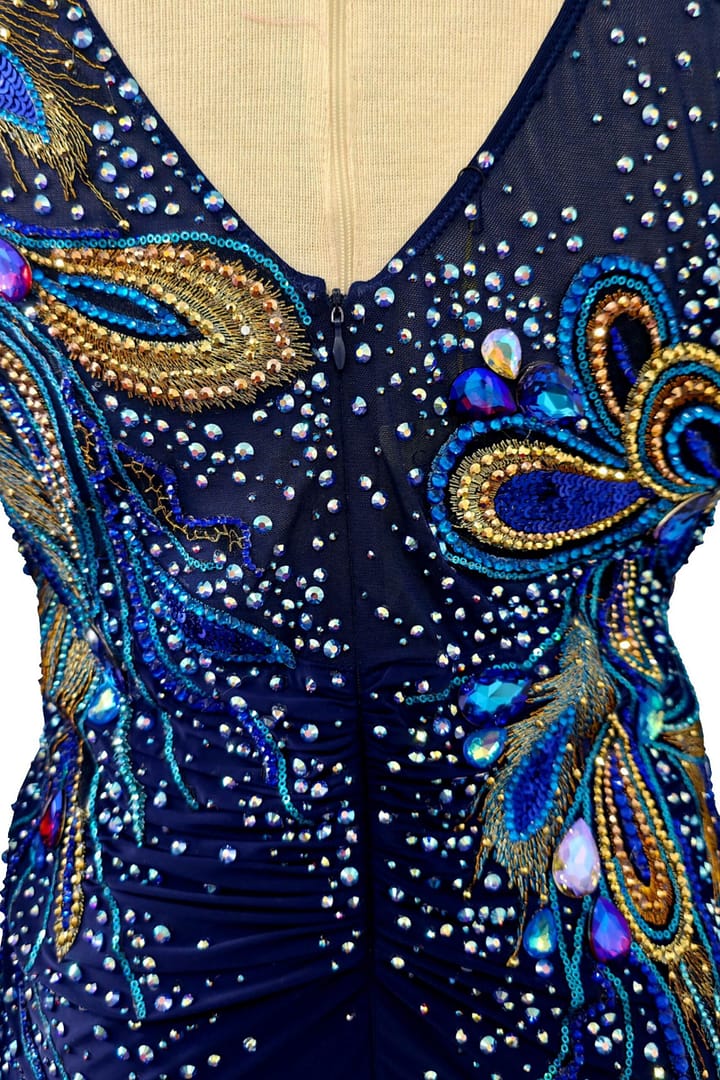 Close-up of Midnight Peacock ballroom dress showing navy bodice crystal detailing and center back zipper