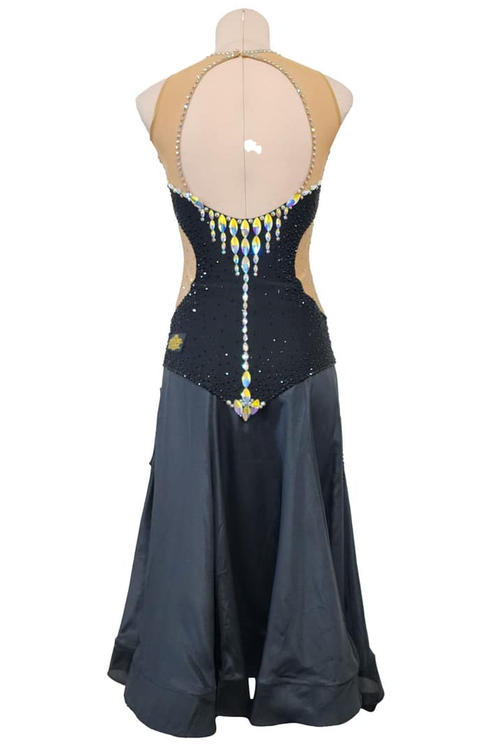 Back view of Midnight Rhythm convertible ballroom gown with nude illusion open-back design, black crystal bodice, and long flowing Smooth skirt.