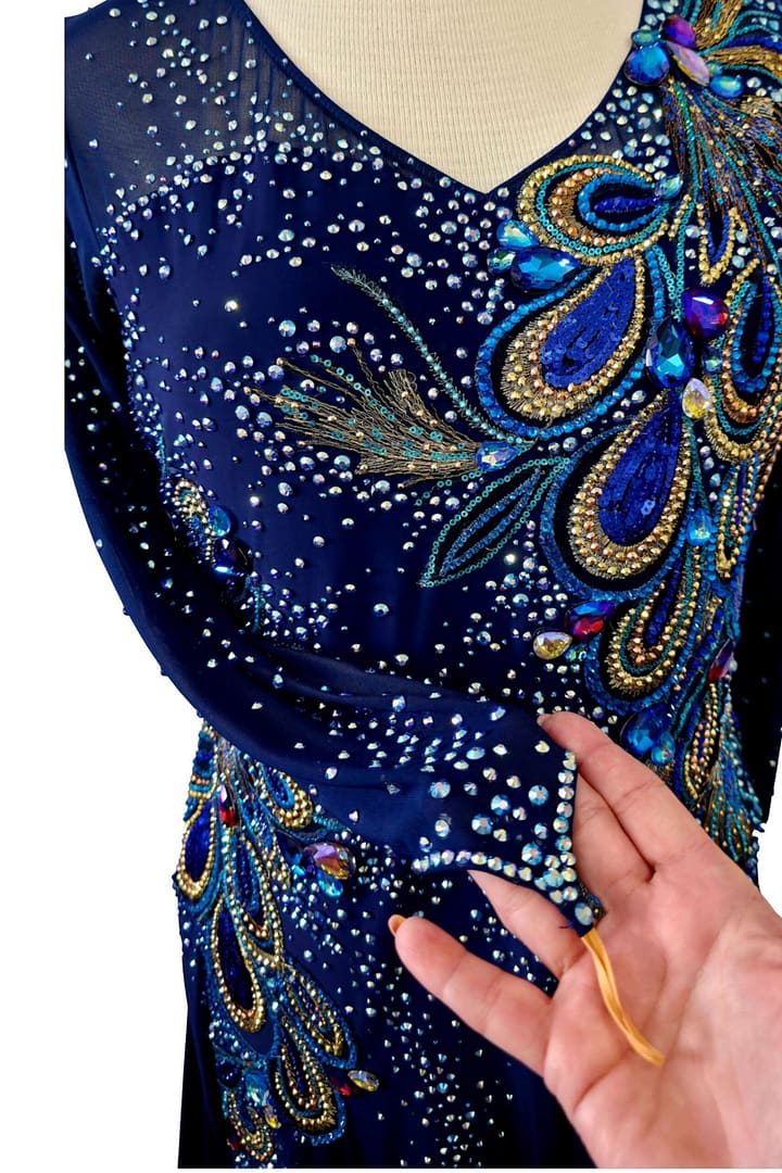 Front view of navy ballroom dress with feather-inspired crystal detailing and sheer sleeve