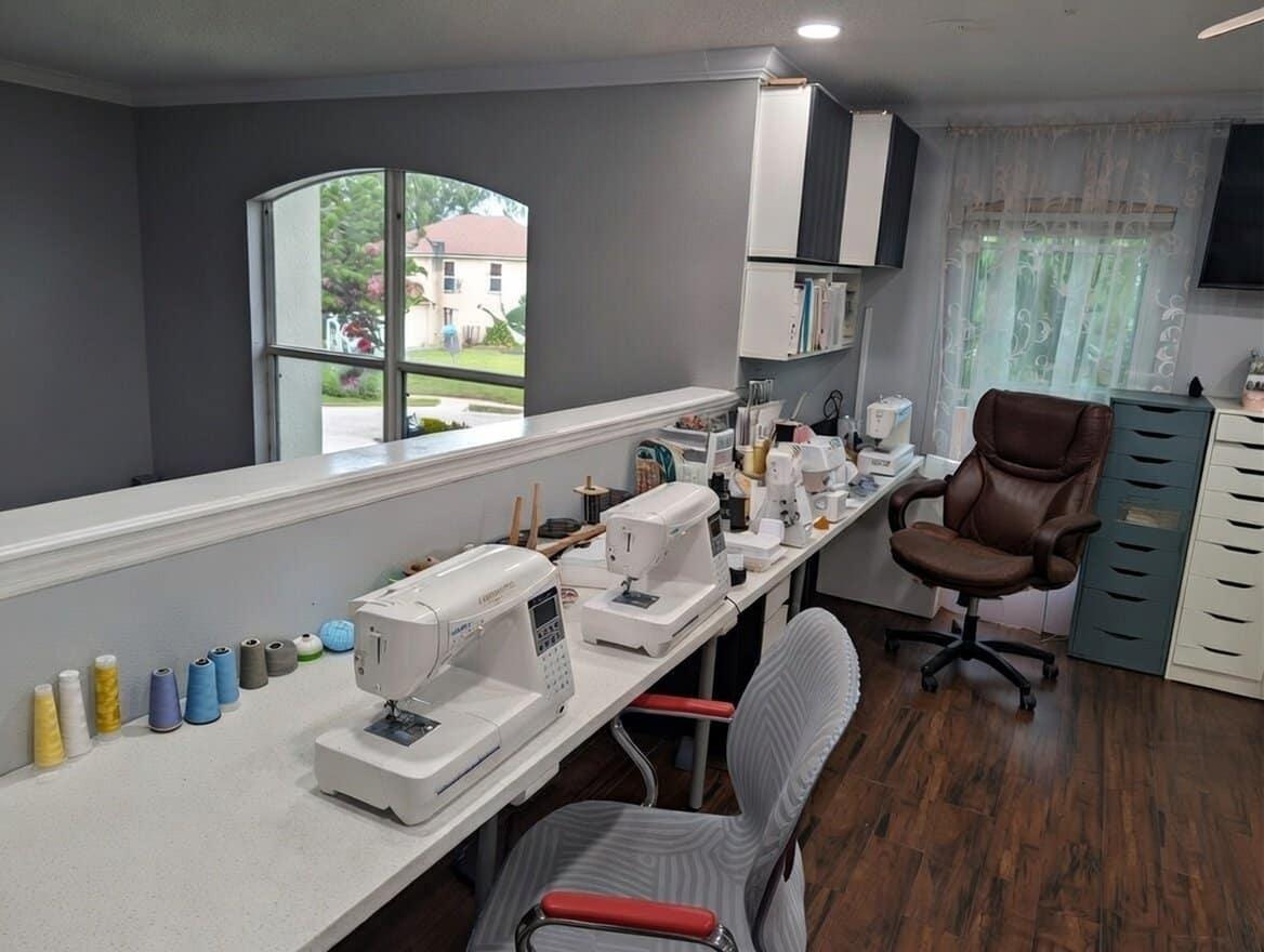 Professional sewing machines and colorful thread spools in a custom design studio.