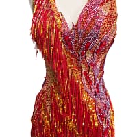 Full front view of the Inferno Cascade dress on a mannequin, showing the asymmetrical red fringe skirt and heavy stonework.