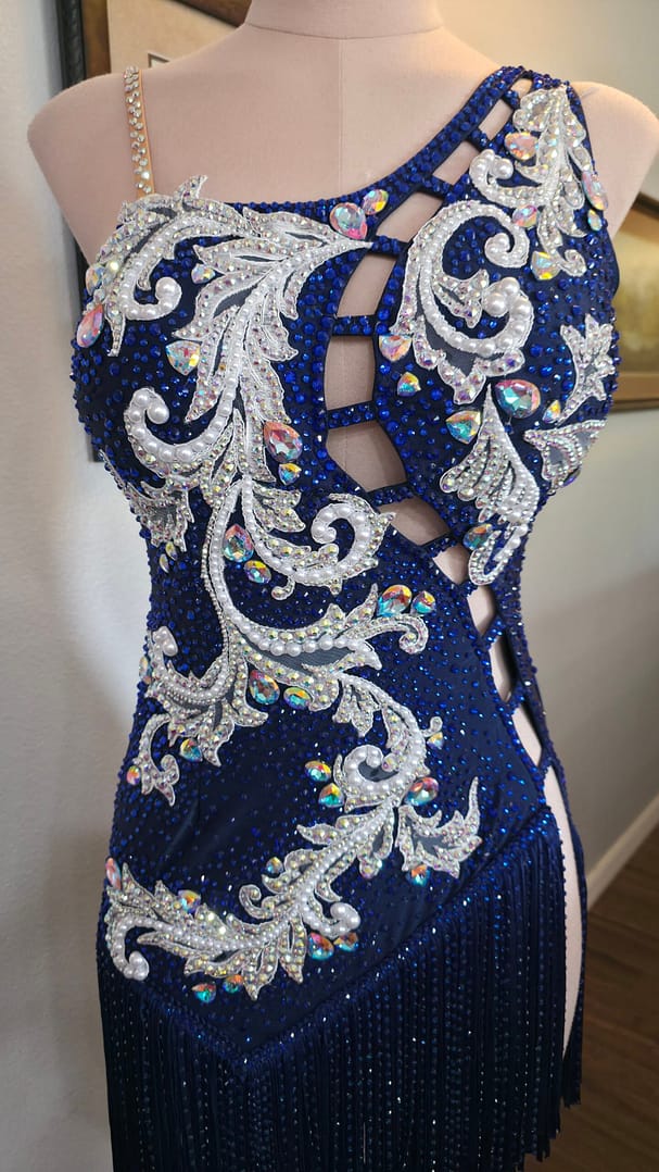 Front bodice close-up of Aurora Royale dress featuring pearl embroidery, AB crystals, and lattice cutout detailing.