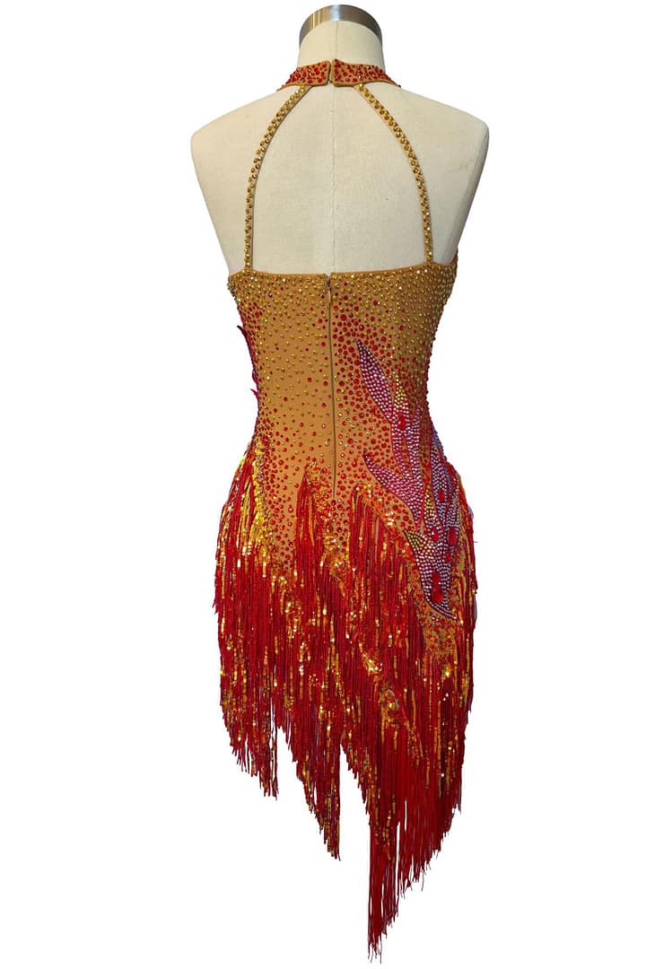 Back view of Inferno Cascade Latin dress featuring nude mesh base with red crystal embellishments and flowing fringe skirt.