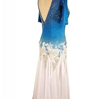 Blue fire ballroom gown — back view — Deep, low V-back bodice that mirrors the blue-to-white ombre and heavy crystal stoning, with white floral appliqué framing the waist.