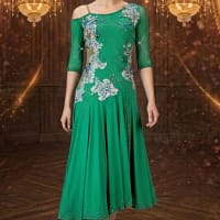 Emerald Motion Latin dress — front view — Bright emerald green Latin dress with three-quarter length sheer sleeves, an off-the-shoulder strap detail, and a heavily stoned bodice with flowing white and blue floral appliqués.