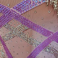 Labana ballroom gown — stonework close-up — Macro view of the stunning contrast between vibrant purple flat-back rhinestones and highly iridescent AB (Aurora Borealis) crystals in zig-zag lines.