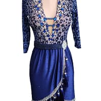 Pala Latin Dress — skirt detail — Blue satin skirt with a diagonal overlap panel, featuring a heavily stoned border and long, black tassels hanging from the hemline for visual impact and movement.