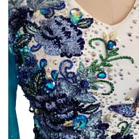 Azure Grace Latin dress bodice detail showing butterfly appliqués, blue floral embroidery, and sparkling crystal stonework