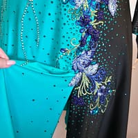 Electric Bloom ballroom dress skirt detail showing flowing teal fabric and scattered rhinestones
