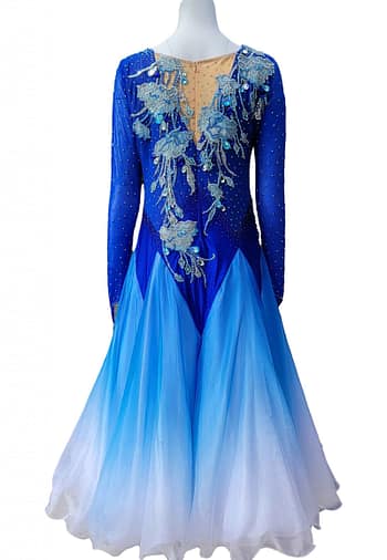 Zinnia ballroom gown — back view — deep blue gown with a nude mesh upper back and a dramatic full skirt in an ombré blue to white fade.