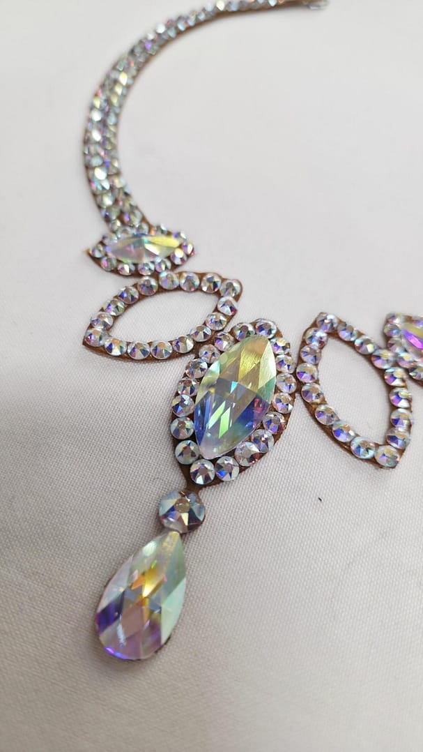 Detail view of Crystal AB stones on a handmade ballroom necklace with high-reflection finish.