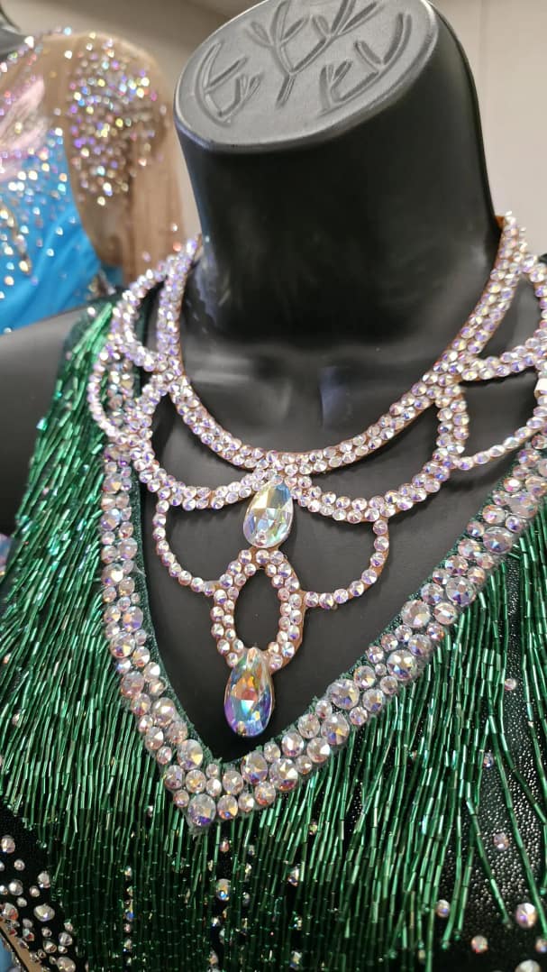 Crystal ballroom necklace styled on mannequin with green competition dance dress