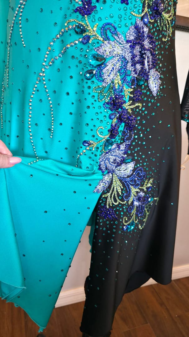 Electric Bloom ballroom dress skirt detail showing flowing teal fabric and scattered rhinestones
