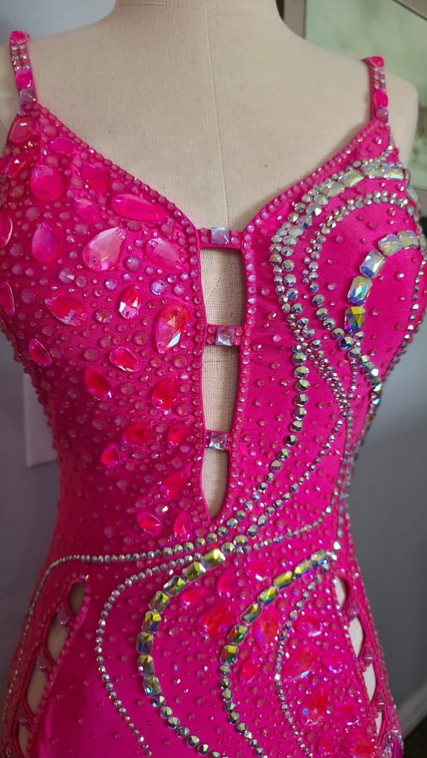 Front bodice view of Malibu Dream ballroom gown featuring pink crystals and cutout detail