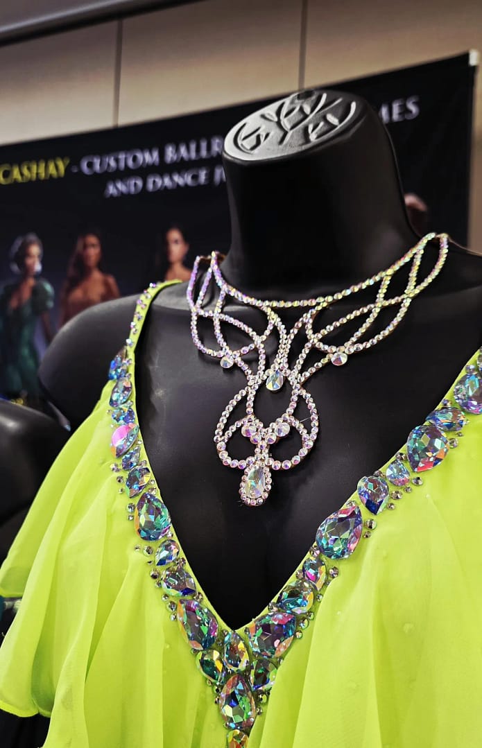 Crystal ballroom necklace styled with bright competition dress on mannequin