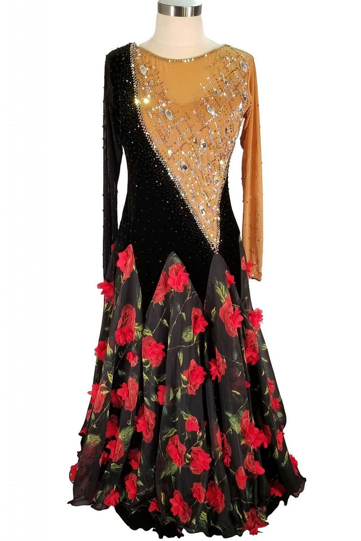 Fia ballroom gown — front view — A Standard dress featuring a V-neck black velvet panel on the bodice contrasting with a sheer tan mesh panel covered in large iridescent crystals. The full skirt is black with striking red floral appliqués and print.