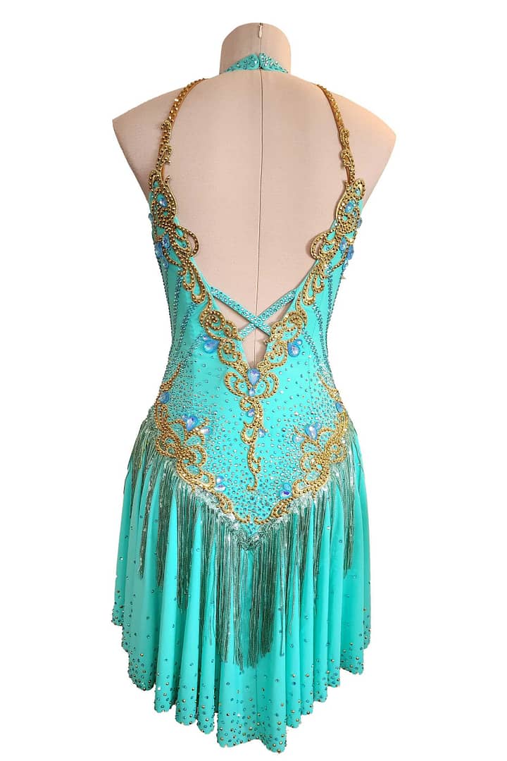 Ashcroft Latin dress - back view - Teal fabric, gold appliqué, open V-back, and fringe skirt.
