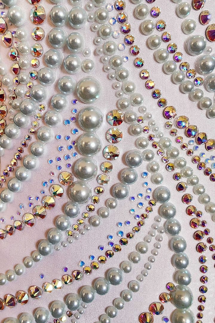 Gia Latin dress — stonework close-up — silver floral appliqué with delicate rhinestone accents and beadwork over bright pink satin base.