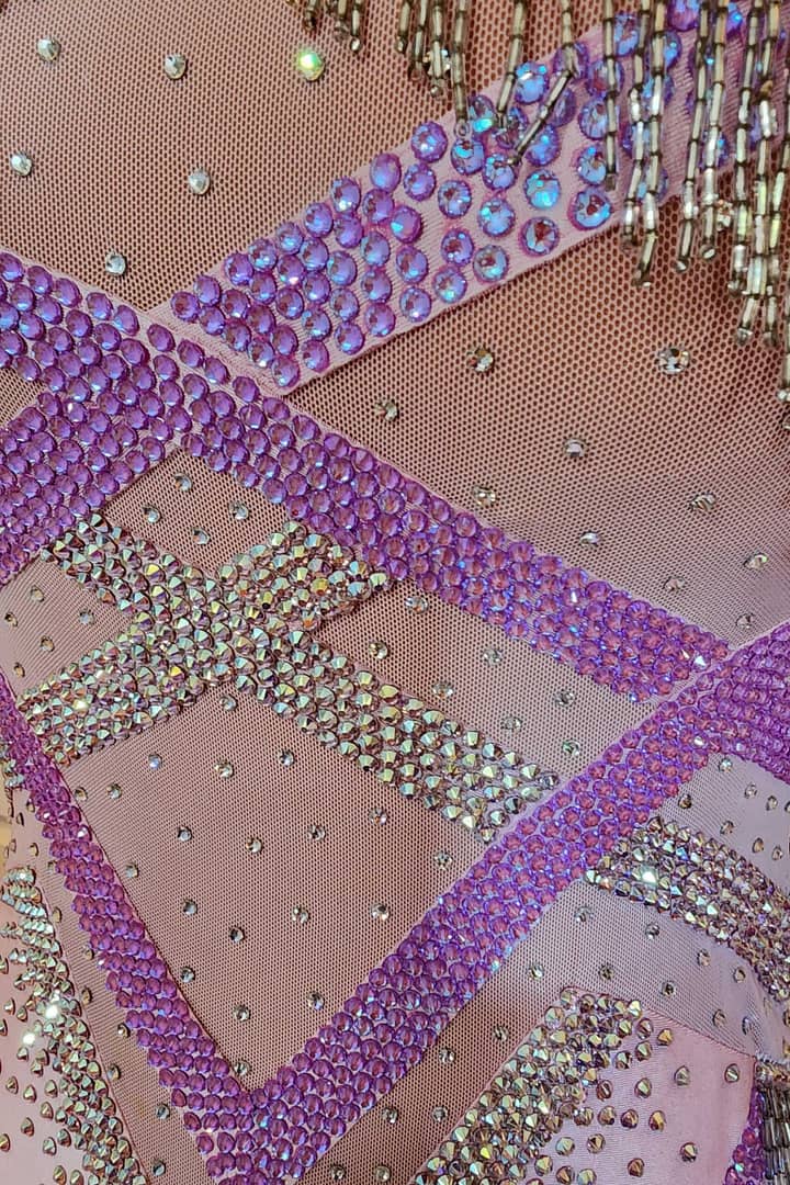 Labana ballroom gown — stonework close-up — Macro view of the stunning contrast between vibrant purple flat-back rhinestones and highly iridescent AB (Aurora Borealis) crystals in zig-zag lines.