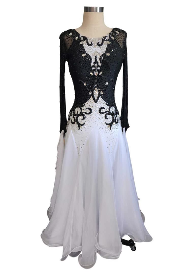 Lauren ballroom gown — front view in mannequin — The black and white Standard gown displayed on a mannequin, showcasing its long sheer black sleeves, intricate crystal work on the bodice, and voluminous white skirt.