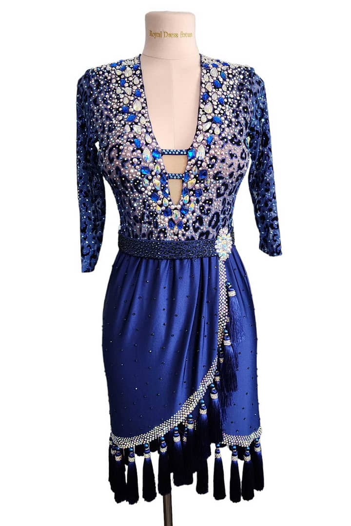 Pala Latin Dress — skirt detail — Blue satin skirt with a diagonal overlap panel, featuring a heavily stoned border and long, black tassels hanging from the hemline for visual impact and movement.