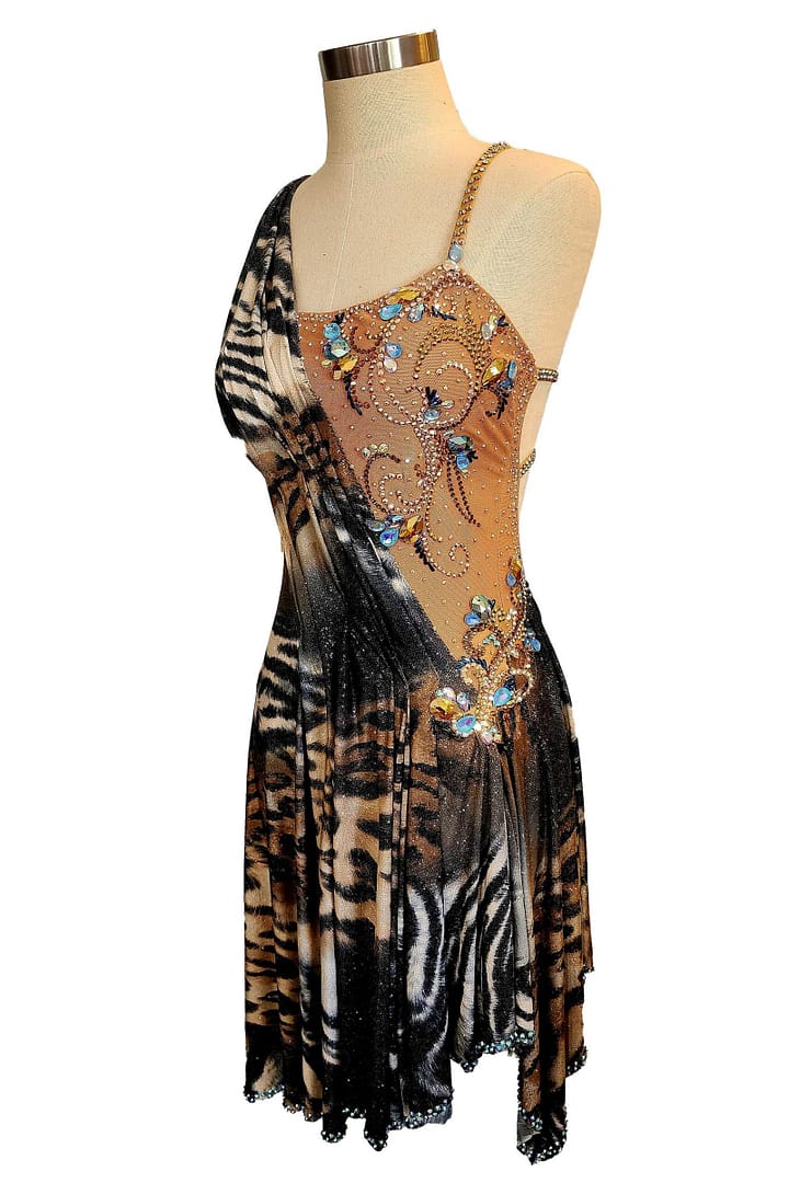 Kaya Latin dress — 3/4 side view — sleeveless Latin dress with a draped animal print front and a handkerchief hemline trimmed with blue crystals.