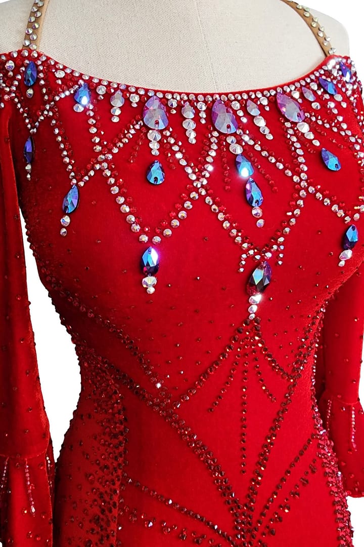 Amira Ballroom dress — bodice detail — close-up of swirling stoning pattern on mesh, featuring AB crystals and small red pearls.