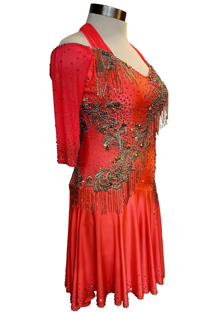 Crush Latin dress — side detail — close-up of the hip cutouts and the thick black bead fringe layered over orange mesh.