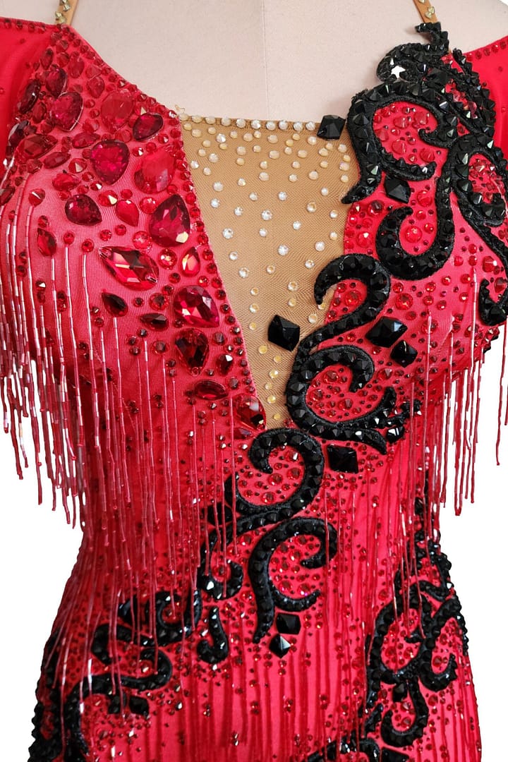 Nyla Latin dress — bodice detail — red rhinestones, black swirl appliqué, nude mesh, and beaded fringe.