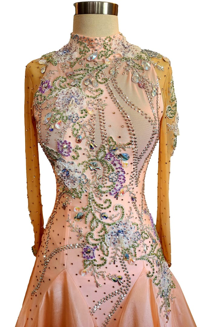Peach ballroom gown — bodice detail — close-up of the high neckline, nude mesh, and multi-colored crystal embellishment forming a delicate floral design.