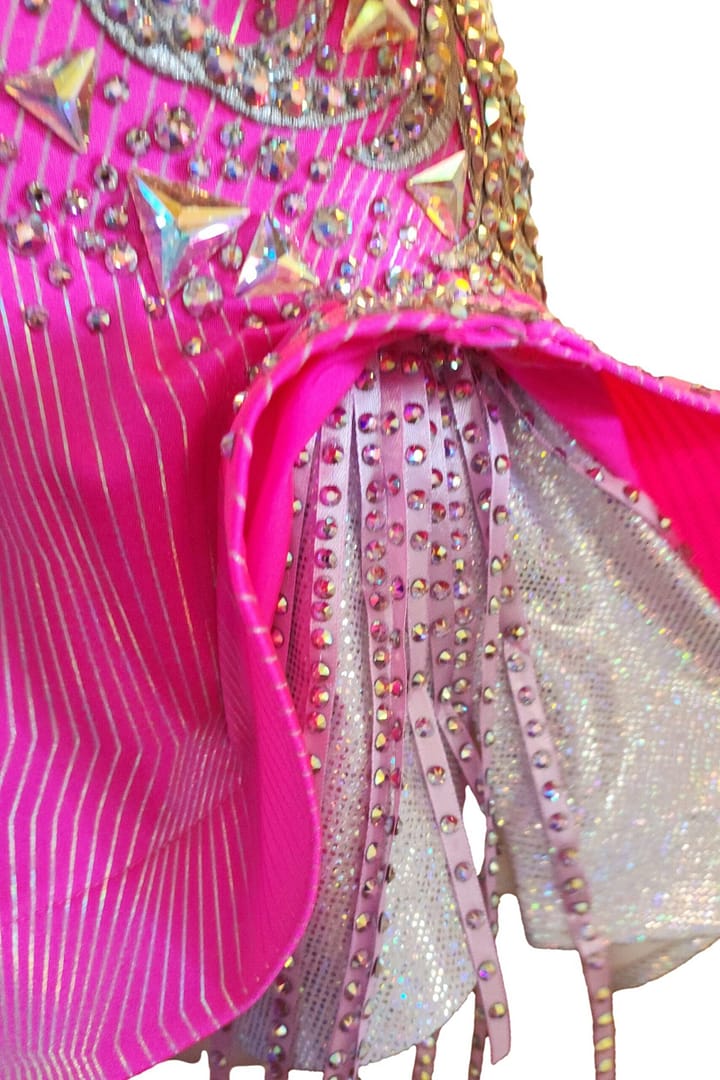 Skirt detail showing flared pink panels and rhinestone fringe accents
