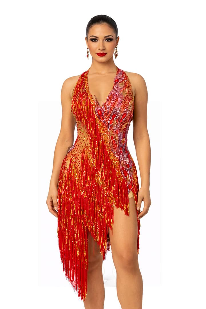 A woman wearing the Inferno Cascade Latin dance dress featuring red fringe, gold sequins, and intricate crystal embellishments.