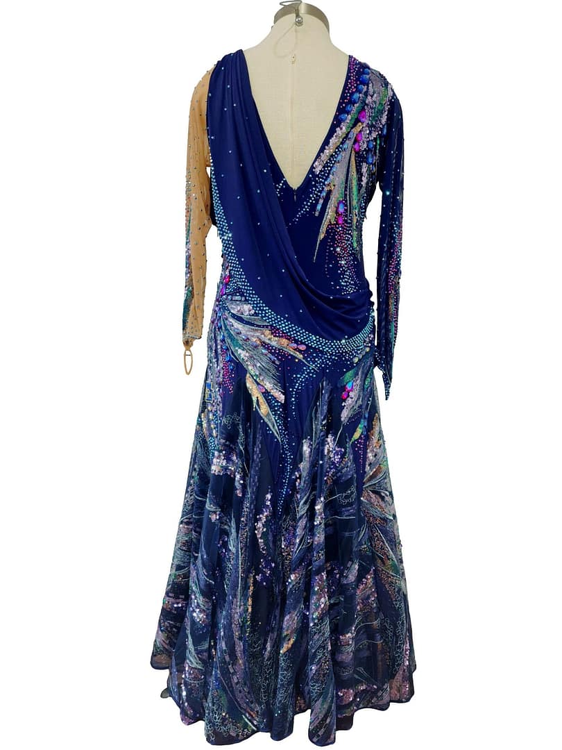 Back view of Royal Horizon ballroom dress featuring deep V-back, crystal embellishments, and layered printed chiffon skirt