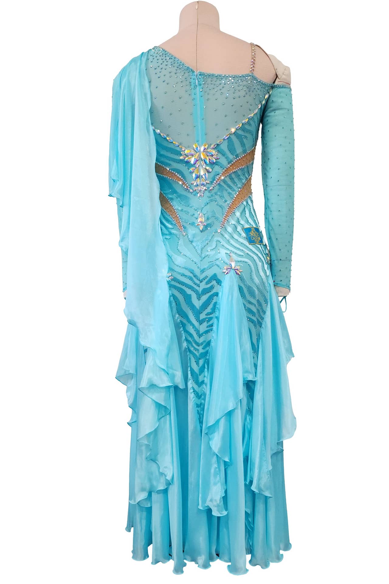 Azure Whispers Latin dress — back view — asymmetrical long-sleeve dress with cascading back ruffles and a central crystal motif accenting the zebra pattern.