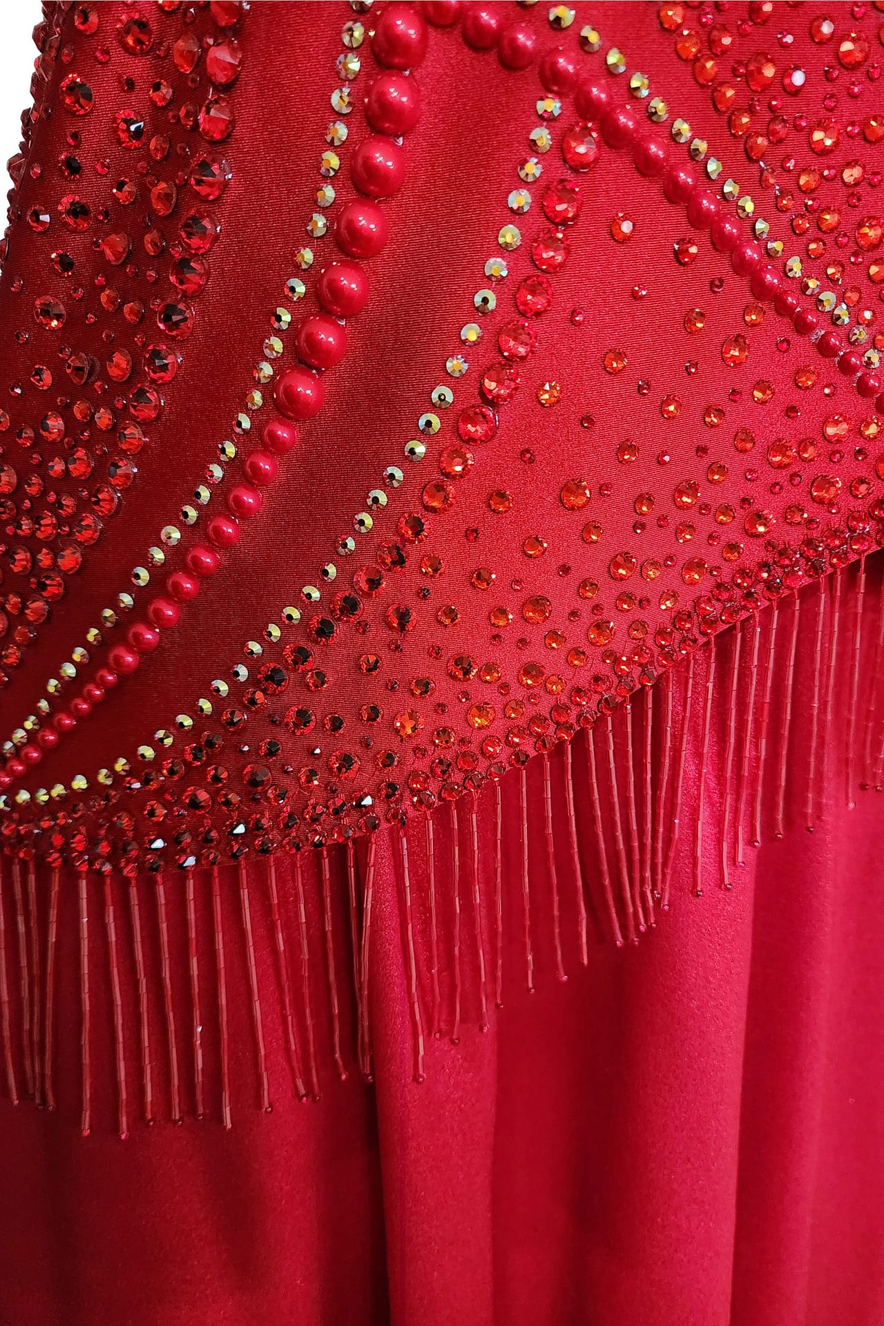 Crimson Flame dress — stonework close-up - red pearl and rhinestone accents forming a fan pattern above the fringe.
