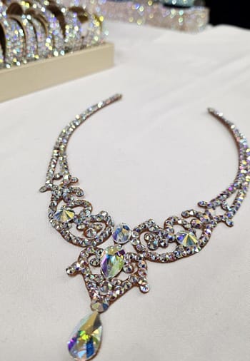 Angled flat lay of crystal ballroom necklace featuring crystal AB stones and central teardrop detail