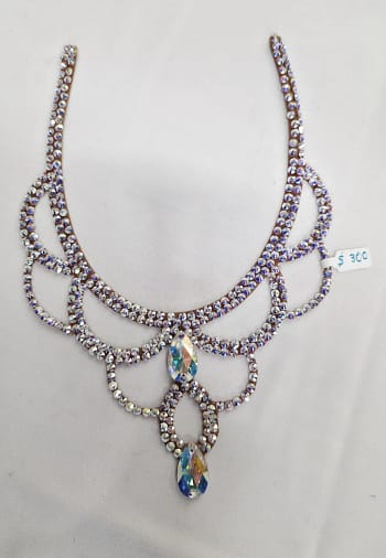Full flat lay of large crystal ballroom necklace with layered scroll pattern and dual teardrop crystals