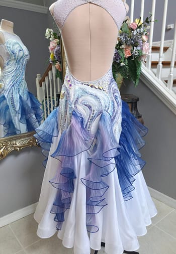 Crystal Current, a sparkling country dance dress with intricate crystal detailing, an elegant open back, and flowing blue-lilac ruffles.