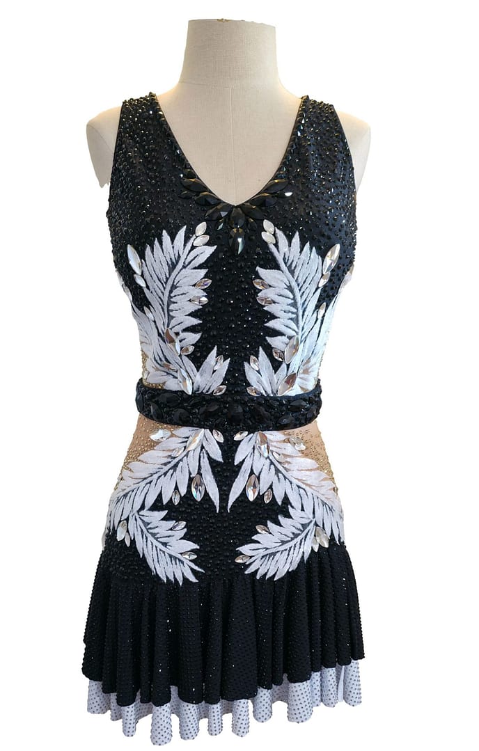 Front detail of Onyx Whisper Performance Series Latin dress with black crystal bodice and white leaf pattern embellishments