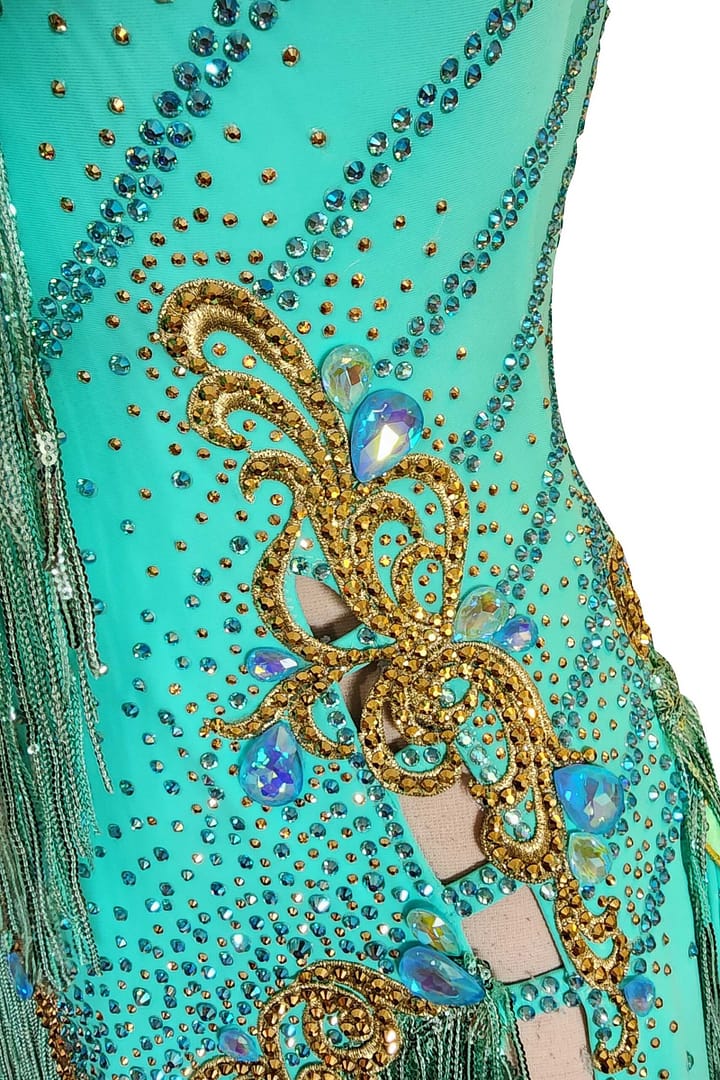 Ashcroft Latin Dress - stonework close‑up - Gold scrollwork, AB crystal tear drops, and cutouts with fringe.