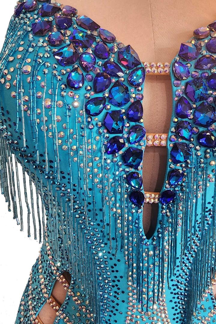 Carla Latin dress — stonework detail - close-up of neckline showing large royal blue teardrop crystals around a keyhole cutout and fringe.