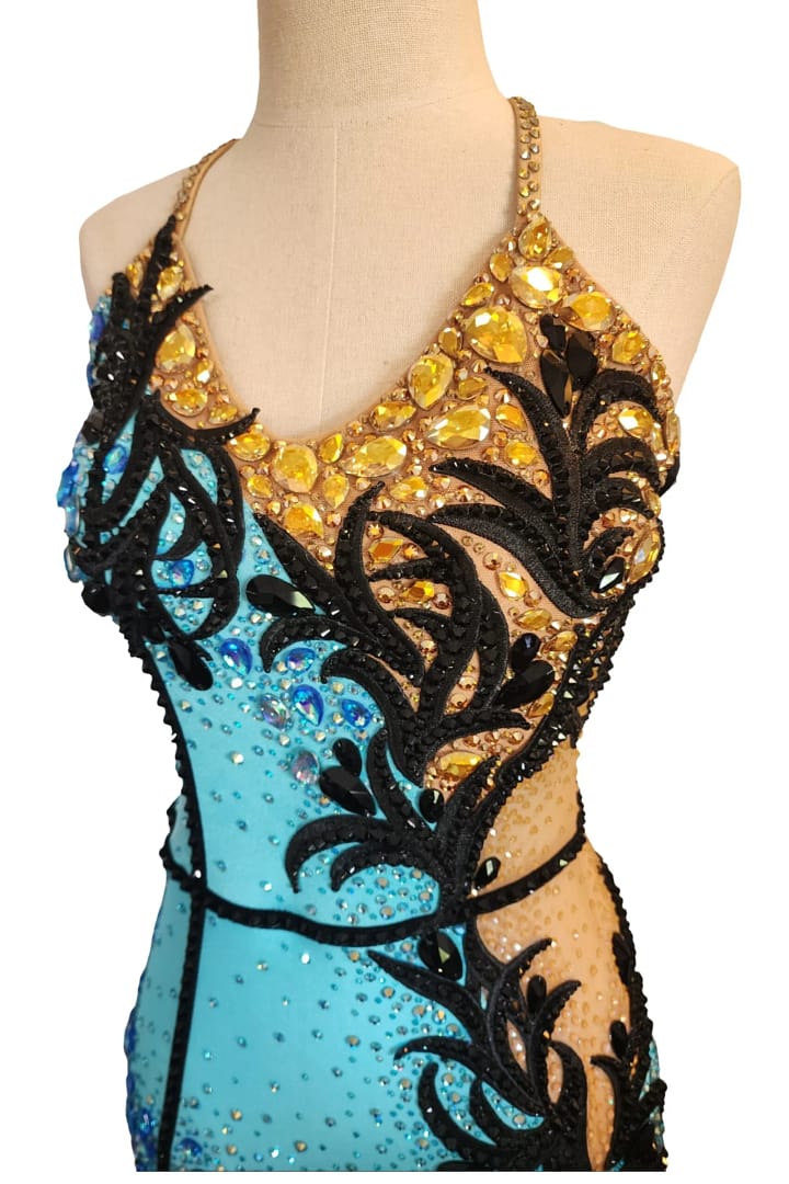 Jayla Latin dress — bodice detail — close-up of yellow teardrop crystals and black scrollwork appliqué on the gold half.